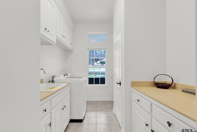 laundry area featuring cabinets, light tile patterned flooring, and independent washer and dryer