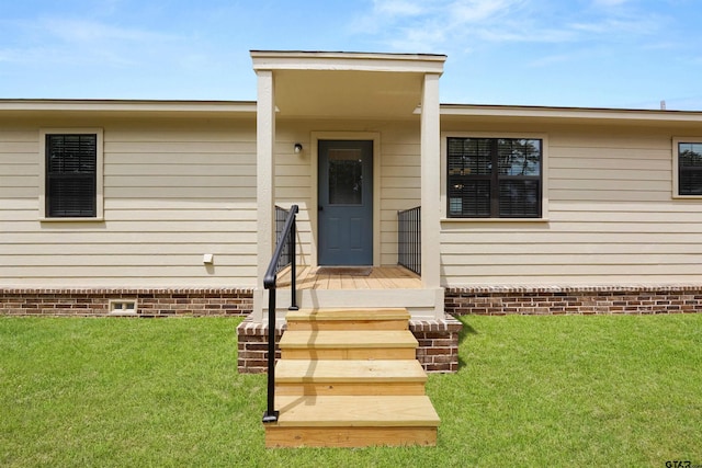property entrance featuring a lawn and crawl space