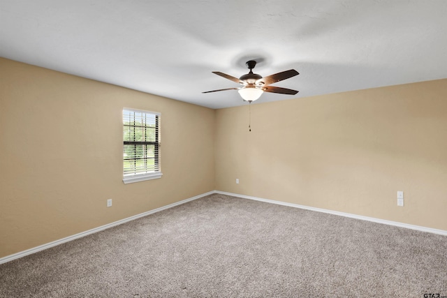 carpeted empty room featuring baseboards and ceiling fan