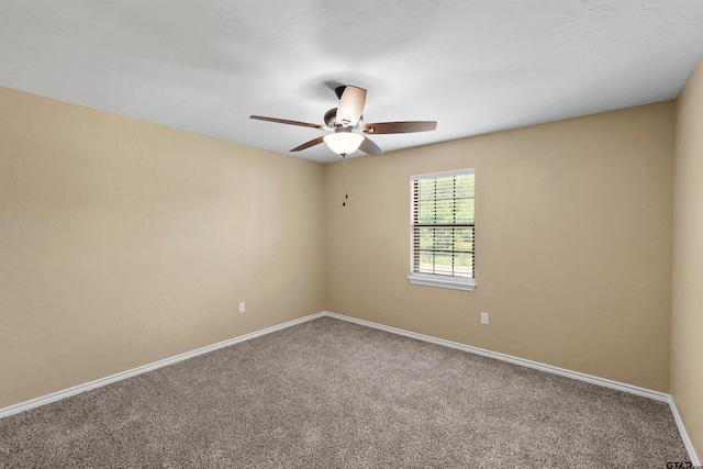 unfurnished room featuring a ceiling fan, baseboards, and carpet