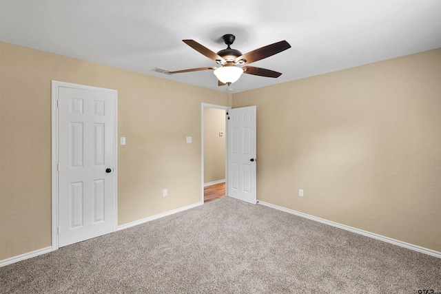 unfurnished bedroom featuring baseboards, visible vents, ceiling fan, and carpet