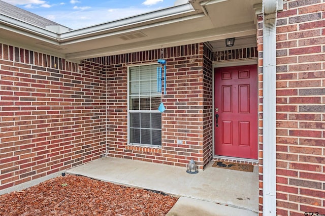 entrance to property featuring brick siding