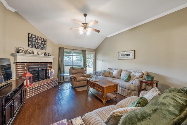 living area with a ceiling fan, wood finished floors, crown molding, a brick fireplace, and vaulted ceiling