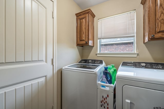 clothes washing area with cabinet space and washer and clothes dryer