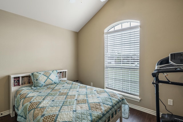 bedroom featuring lofted ceiling, baseboards, and dark wood-style flooring