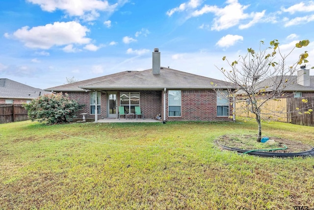 back of property with a patio area, a lawn, and fence