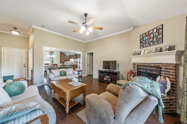 living area featuring a ceiling fan, visible vents, baseboards, dark wood finished floors, and a brick fireplace