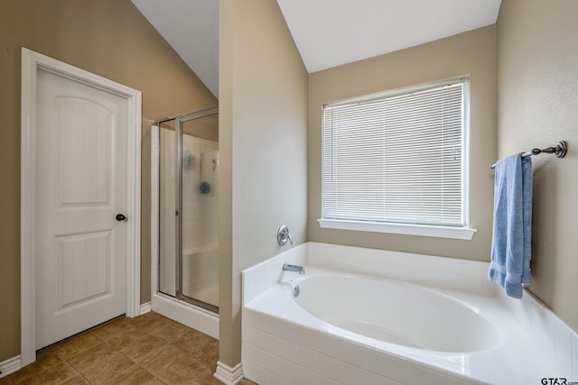 bathroom featuring lofted ceiling, a garden tub, a stall shower, and tile patterned floors