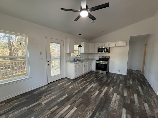 kitchen featuring dark wood-type flooring, sink, decorative light fixtures, stainless steel appliances, and white cabinets