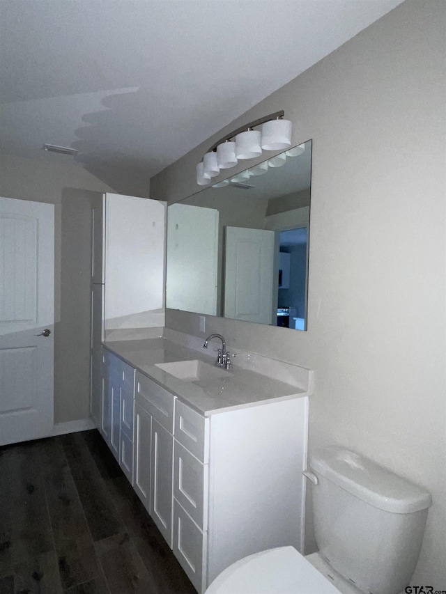 bathroom with vanity, toilet, and wood-type flooring