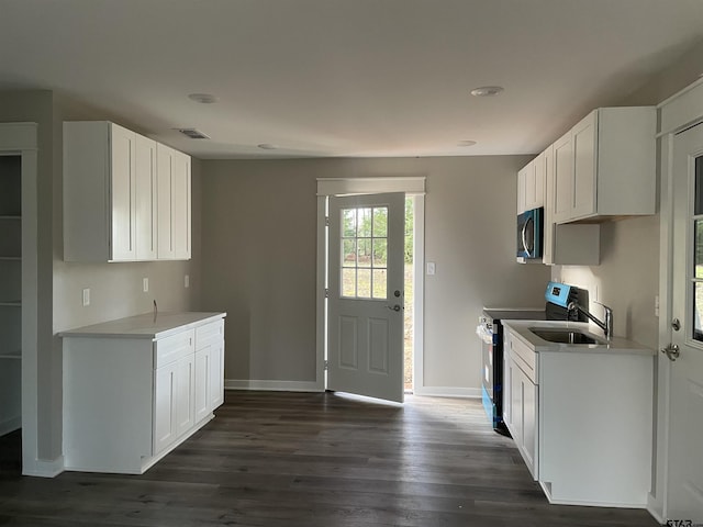 kitchen featuring white cabinets, dark hardwood / wood-style flooring, electric range, and sink