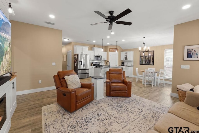 17127 Meadowview Ln, Lindale, TX 75771 - living room featuring ceiling fan, a chandelier, light wood finished floors, recessed lighting, and a glass covered fireplace