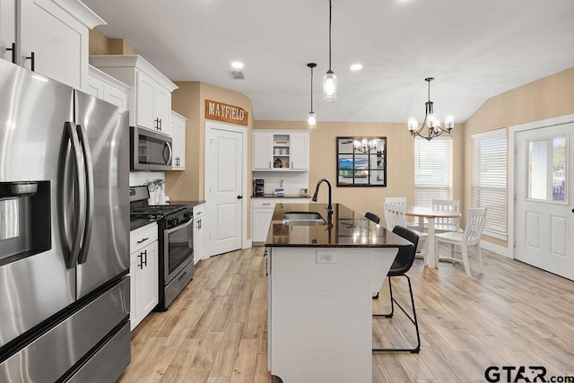 17127 Meadowview Ln, Lindale, TX 75771 - kitchen featuring appliances with stainless steel finishes, open shelves, a chandelier, a breakfast bar area, and white cabinetry