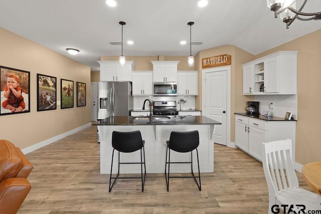 17127 Meadowview Ln, Lindale, TX 75771 - kitchen featuring appliances with stainless steel finishes, dark countertops, open shelves, a breakfast bar, and recessed lighting