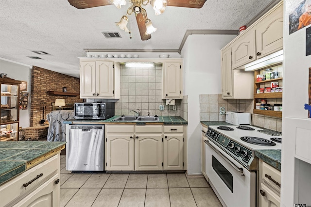 kitchen featuring sink, appliances with stainless steel finishes, ornamental molding, ceiling fan, and light tile patterned floors