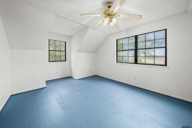 additional living space featuring lofted ceiling, a textured ceiling, and ceiling fan