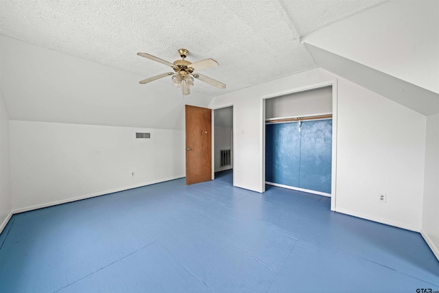 bonus room featuring lofted ceiling, a textured ceiling, and ceiling fan