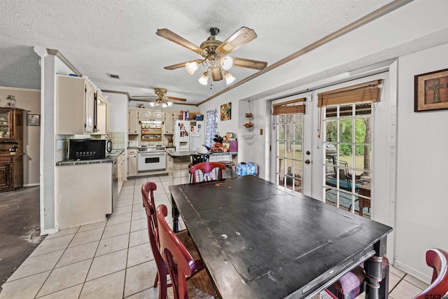 dining room featuring a textured ceiling, light tile patterned floors, and crown molding