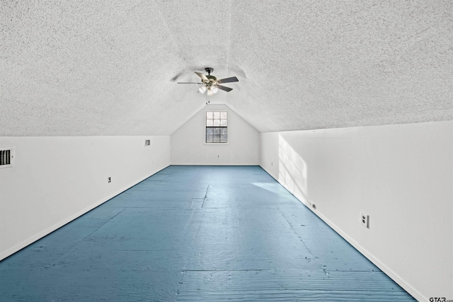 additional living space featuring lofted ceiling, a textured ceiling, and ceiling fan