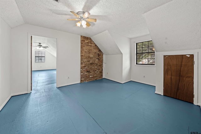 additional living space with a textured ceiling, ceiling fan, and vaulted ceiling