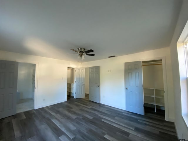 unfurnished bedroom featuring dark wood-type flooring, ceiling fan, and ensuite bath