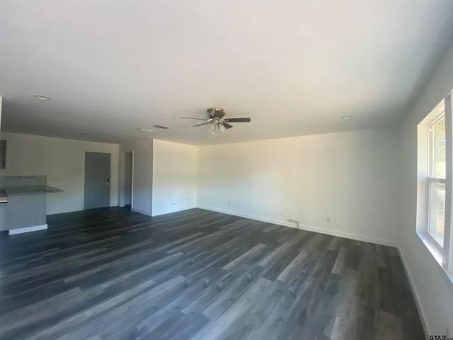 unfurnished living room featuring ceiling fan and dark hardwood / wood-style flooring