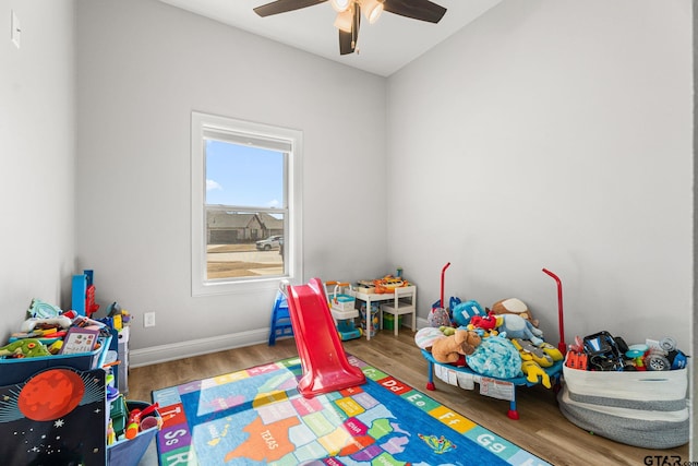 playroom with ceiling fan, baseboards, and wood finished floors