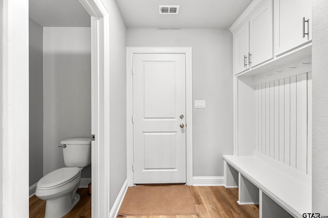 mudroom featuring light wood-type flooring, visible vents, and baseboards