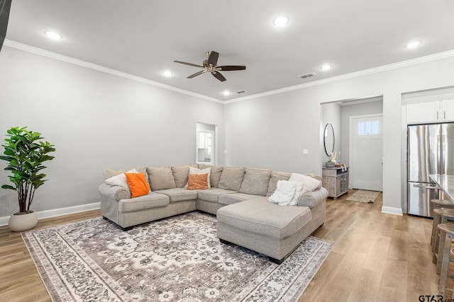 living area featuring light wood-type flooring, visible vents, and baseboards