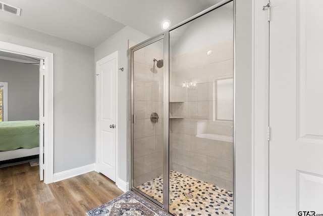 full bath with baseboards, visible vents, ensuite bath, wood finished floors, and a shower stall