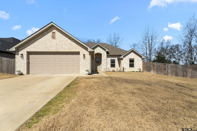 view of front of house featuring driveway, a garage, brick siding, fence, and a front yard