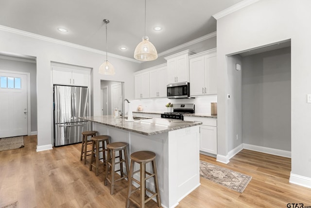 kitchen with decorative backsplash, a breakfast bar area, light stone countertops, stainless steel appliances, and a sink