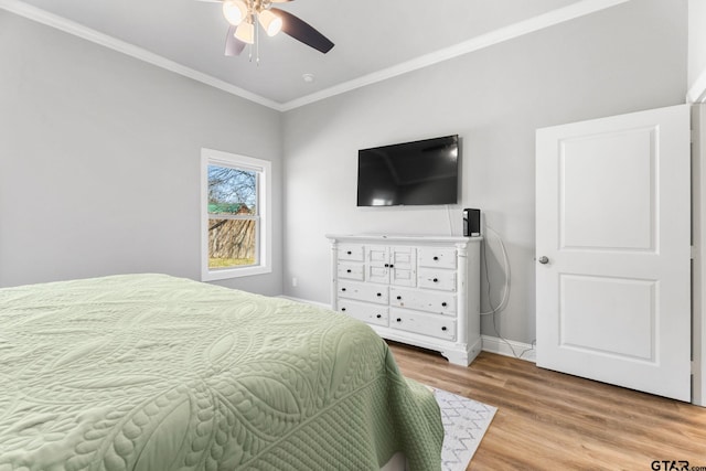 bedroom featuring light wood-style flooring, ornamental molding, ceiling fan, and baseboards