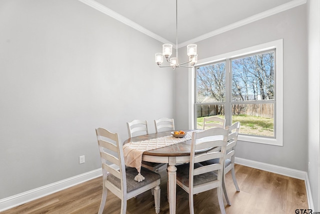 dining area with ornamental molding, a wealth of natural light, and light wood-style floors