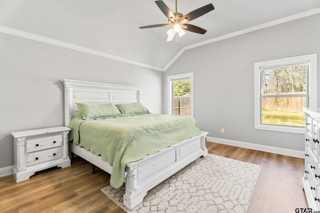 bedroom with vaulted ceiling, multiple windows, and light wood-style floors