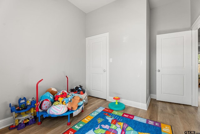 playroom featuring baseboards and wood finished floors