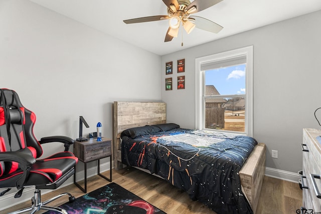 bedroom featuring ceiling fan, baseboards, and wood finished floors