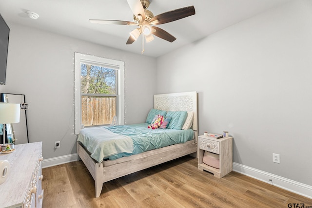 bedroom with light wood-style floors, baseboards, and a ceiling fan