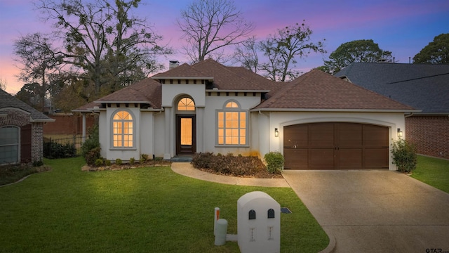 mediterranean / spanish-style home featuring a garage and a lawn