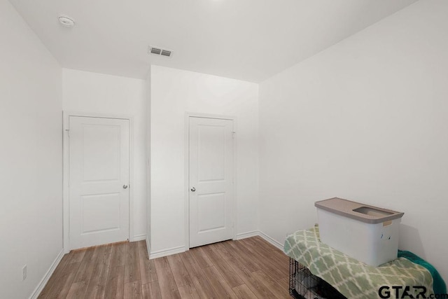 interior space with visible vents, wood finished floors, and baseboards