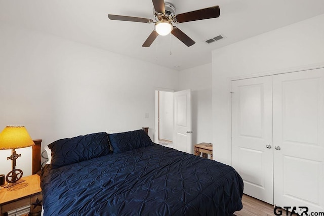 bedroom with a closet, visible vents, ceiling fan, and light wood-type flooring