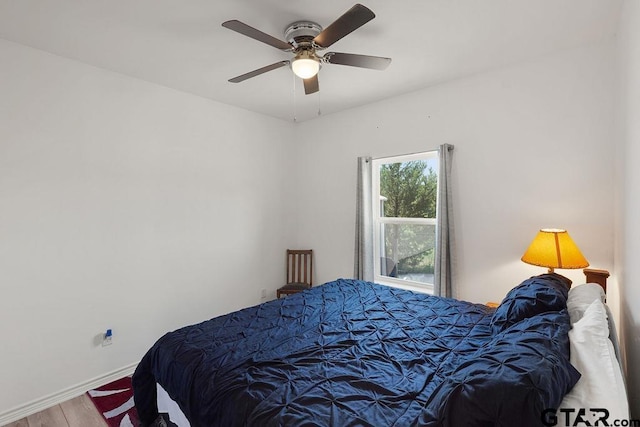 bedroom featuring ceiling fan, wood finished floors, and baseboards