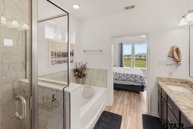 ensuite bathroom featuring ensuite bath, a bath, vanity, visible vents, and a stall shower