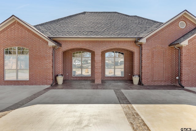 view of exterior entry with a patio