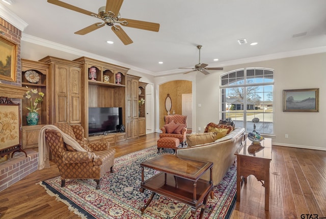 living room with ceiling fan, ornamental molding, and dark wood-type flooring