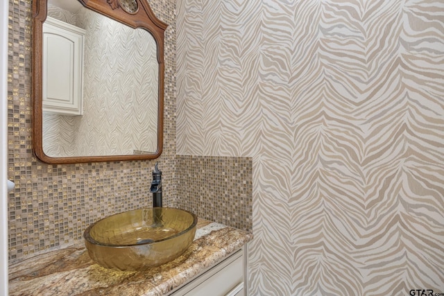 bathroom with tasteful backsplash and vanity