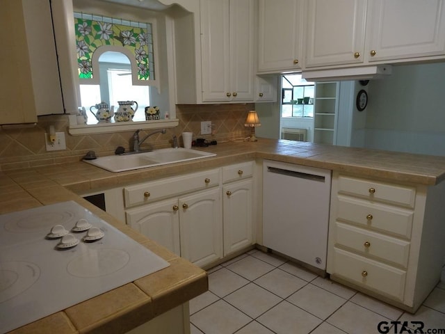 kitchen featuring tile countertops, sink, white cabinets, and white appliances