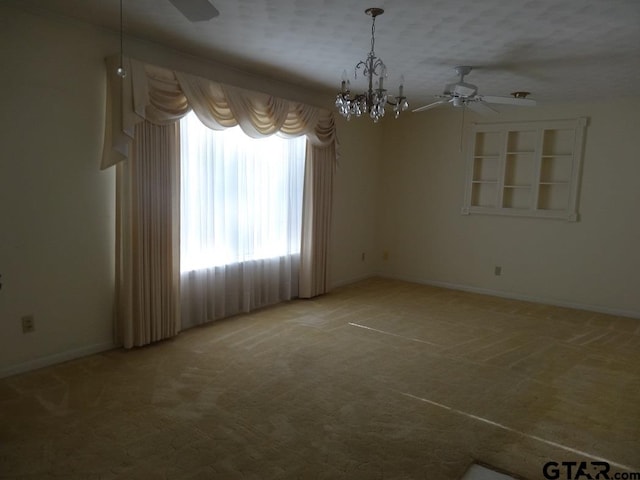 unfurnished room featuring a textured ceiling, carpet, and ceiling fan with notable chandelier