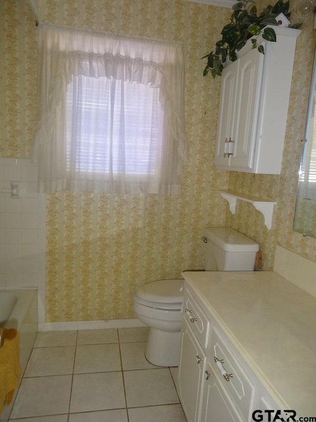 bathroom with tile patterned floors, plenty of natural light, vanity, and toilet