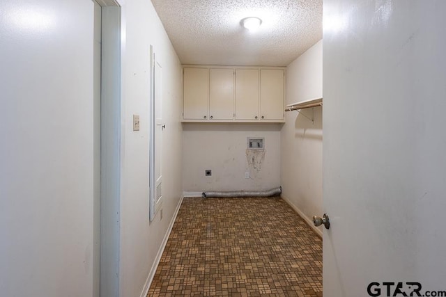 laundry area with hookup for an electric dryer, washer hookup, a textured ceiling, baseboards, and cabinet space